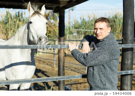 Cheerful man horse farm worker 59434006