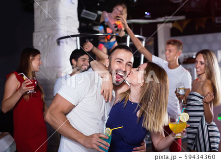 couple of smiling people together in the night club with drinks couple of smiling people together in the night club with drinks 59434360