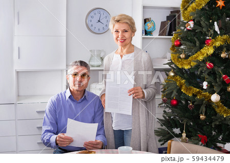 Mature married couple discuss contract and sign important documents Mature married couple discuss contract and sign important documents 59434479