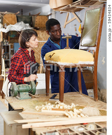 Restorers working with vintage armchair Restorers working with vintage armchair 59434834