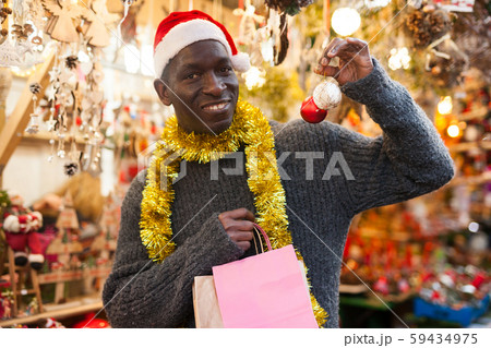 Laughing guy in Santa hat after Christmas shopping 59434975