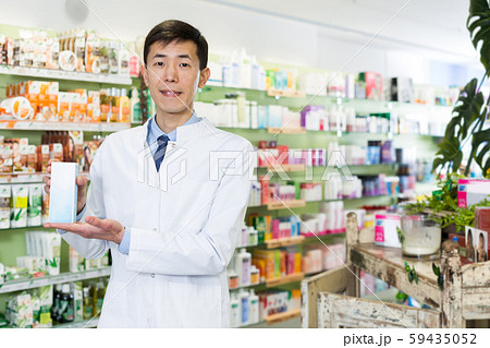 Chinese male pharmacist posing with medicines in medical shop Chinese male pharmacist posing with medicines in medical shop 59435052