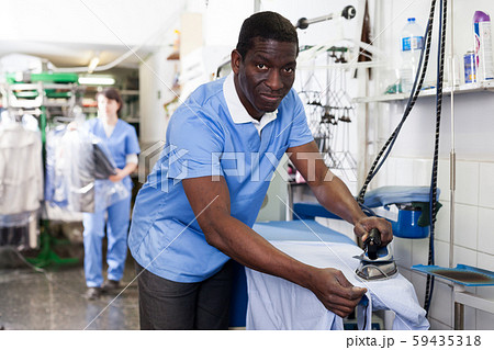Man ironing clothes Man ironing clothes 59435318