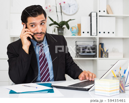 Adult man is surprised while talking phone with his partner Adult man is surprised while talking phone with his partner 59435461