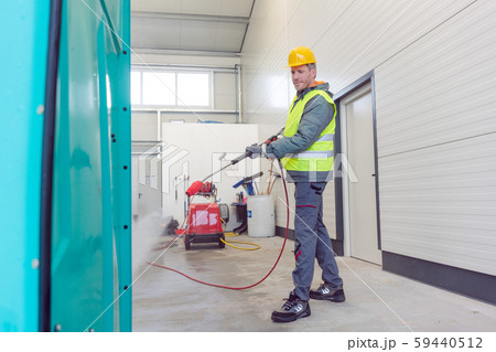 Worker cleaning a rental or mobile toilet 59440512