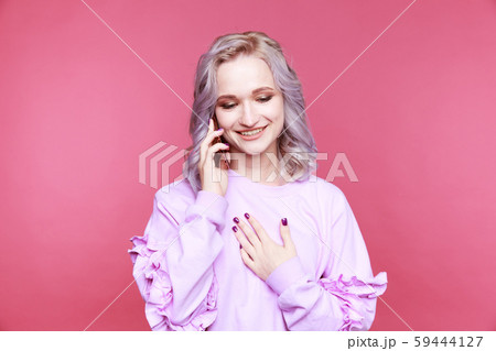 Glad cute young woman talking phone and smiling isolated. Glad cute young woman talking phone and smiling isolated. 59444127