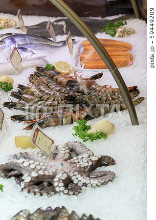 Fresh seafood on ice in farmers market. Sale of shrimps, fish, octopus. Showcases of seafood market 59449209