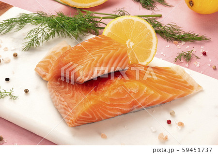 Slices of salmon with lemon and dill, close-up with salt and pepper, cooking fish, on a pink 59451737