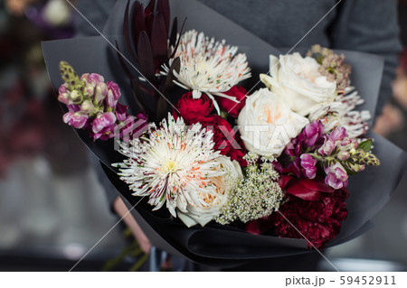 Beautiful bouquet of mixed flowers with peonies. The work of the florist. Flower delivery 59452911