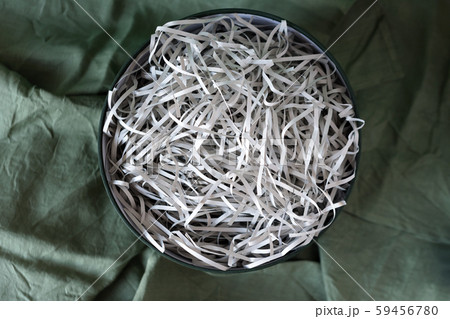 Opened gift box with decorative straw, filler, shavings, paper ribbons. Cut paper for packaging Opened gift box with decorative straw, filler, shavings, paper ribbons. Cut paper for packaging 59456780