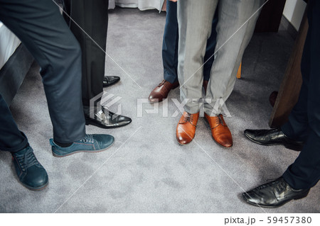 Groom and groomsmen men in blue suits standing in group with closeup of shoes and feet 59457380