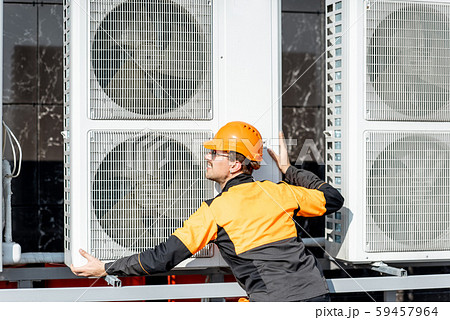 Workman installing outdoor unit of the air conditioner 59457964