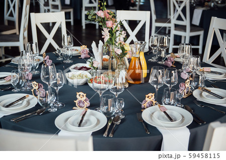 Glasses, flowers, fork, knife served for dinner in restaurant with cozy interior, Glasses, flowers, fork, knife served for dinner in restaurant with cozy interior, 59458115