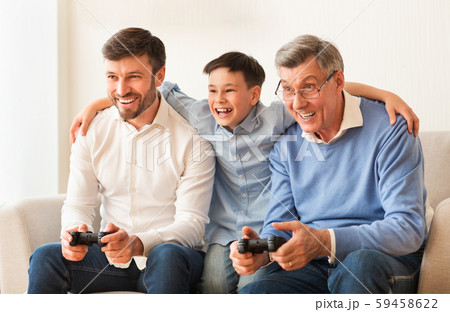 Elderly Man, Mature Son And Grandson Playing Videogame At Home 59458622