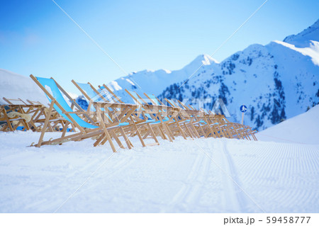 Sun loungers against backdrop of mountains at winter resort 59458777