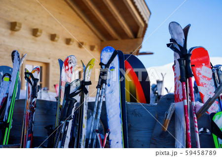 Image of multi-colored skis and snowboards in snow at winter resort in afternoon. Image of multi-colored skis and snowboards in snow at winter resort in afternoon. 59458789