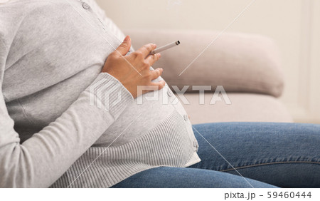 Unrecognizable Pregnant Lady Smoking Sitting On Sofa At Home, Cropped Unrecognizable Pregnant Lady Smoking Sitting On Sofa At Home, Cropped 59460444