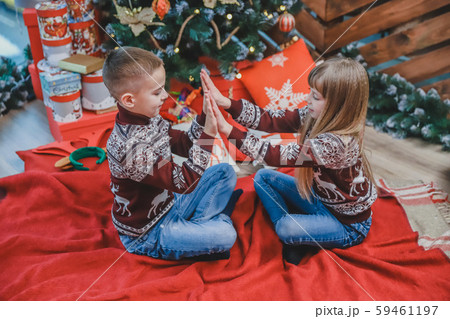 Portrait of boy and girl laughing, having fun together, playing clapping game over wooden Christmas 59461197