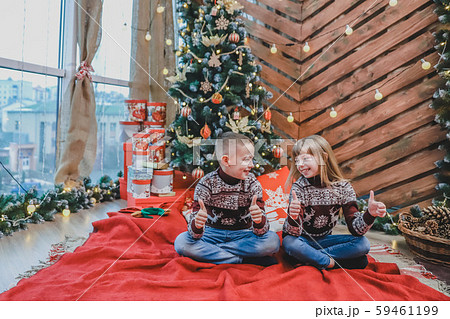 Caucasian siblings weared in claret wool sweaters are showing thumbs up, satisfied with new year Caucasian siblings weared in claret wool sweaters are showing thumbs up, satisfied with new year 59461199