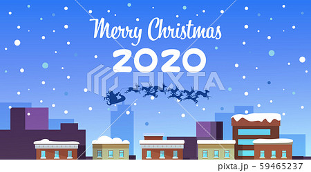 santa claus flying in sleigh with reindeers in night sky over snowy city houses merry christmas 59465237