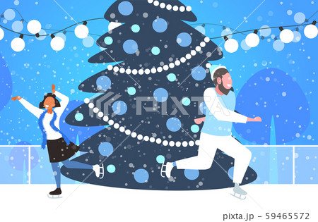 mix race couple at ice-skating outdoor rink with decorated fir tree merry christmas new year mix race couple at ice-skating outdoor rink with decorated fir tree merry christmas new year 59465572