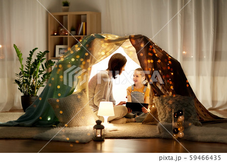 family with tablet pc in kids tent at home 59466435