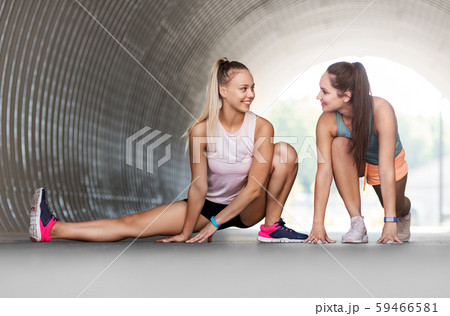 women with fitness trackers stretching outdoors 59466581