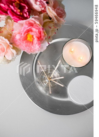 aroma reed diffuser, candle and flowers on table 59466948