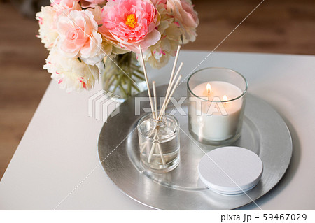 aroma reed diffuser, candle and flowers on table 59467029