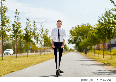 young businessman riding electric scooter outdoors 59467281