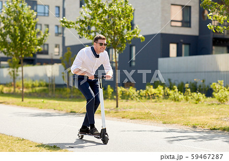 young businessman riding electric scooter outdoors 59467287