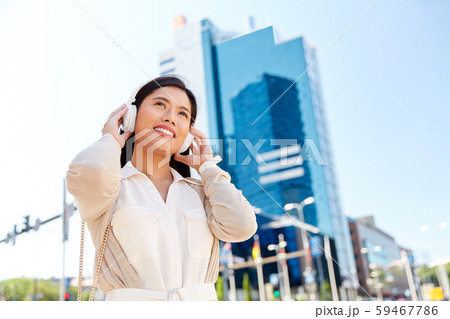 happy smiling asian woman with headphones in city happy smiling asian woman with headphones in city 59467786