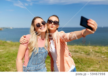 teenage girls or friends taking selfie in summer 59467998