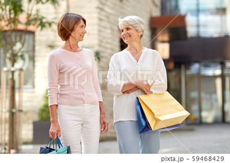 senior women with shopping bags walking in city senior women with shopping bags walking in city 59468429