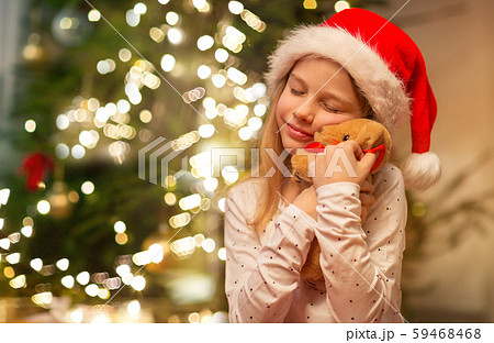 smiling girl in santa hat with christmas gift smiling girl in santa hat with christmas gift 59468468