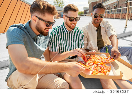 male friends eating pizza with beer on rooftop male friends eating pizza with beer on rooftop 59468587