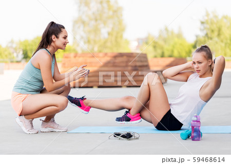 women training and doing bicycle crunches outdoors 59468614