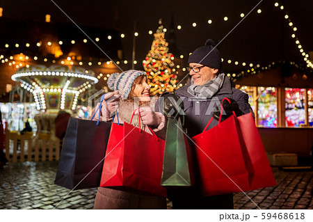 old couple at christmas market with shopping bags 59468618