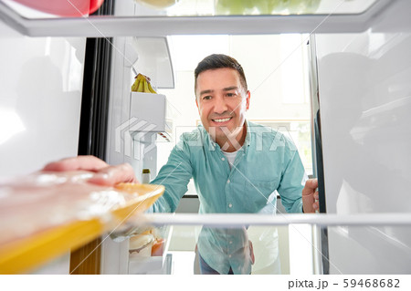 man taking food package from fridge at kitchen man taking food package from fridge at kitchen 59468682