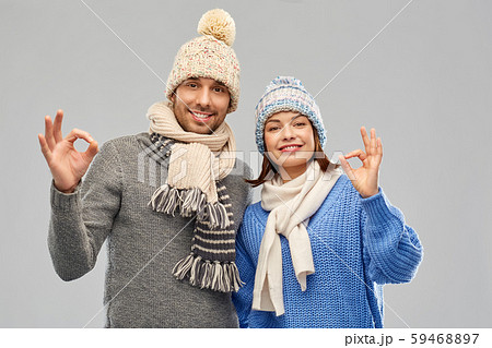 happy couple in winter clothes showing ok sign 59468897