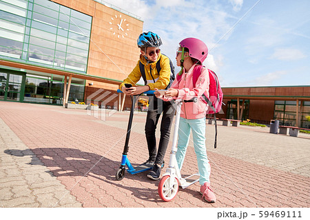 school children with smartphones and scooters school children with smartphones and scooters 59469111