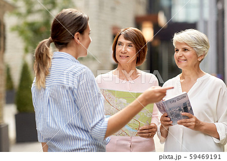 passerby showing direction to senior women in city 59469191