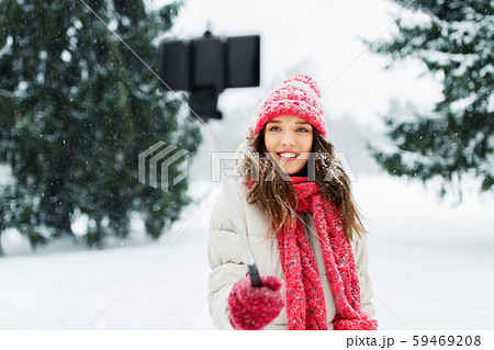 young woman taking selfie by monopod in winter young woman taking selfie by monopod in winter 59469208