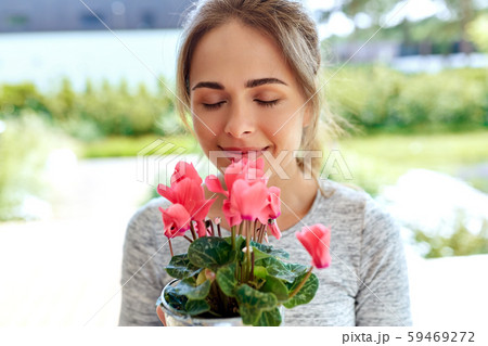 young woman with cyclamen flowers at summer garden 59469272