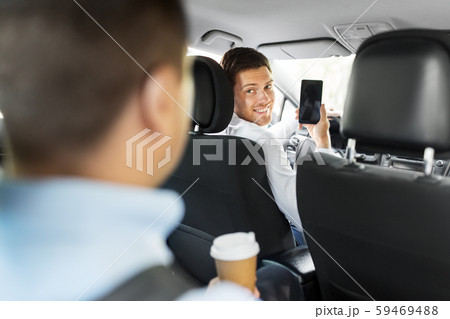 car driver showing smartphone to male passenger car driver showing smartphone to male passenger 59469488