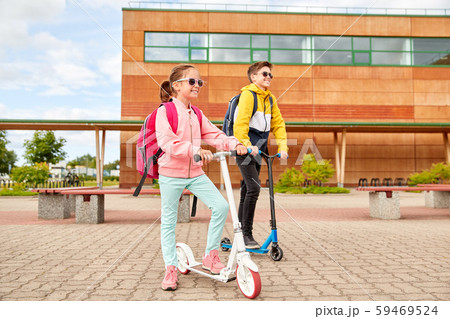happy school children with backpacks and scooters happy school children with backpacks and scooters 59469524