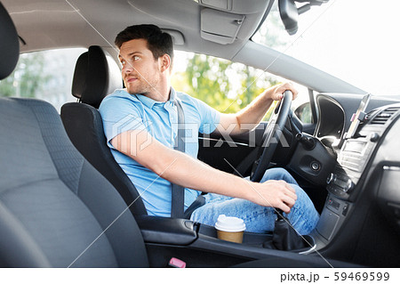 man or driver driving car and looking back 59469599