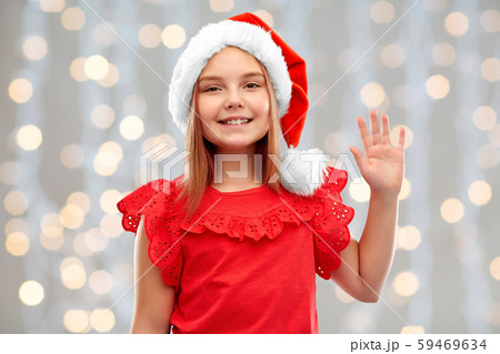 smiling girl in santa helper hat waving hand smiling girl in santa helper hat waving hand 59469634