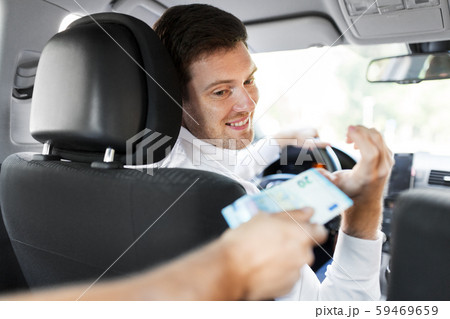 male car driver taking money from passenger male car driver taking money from passenger 59469659