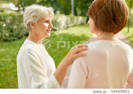 senior women or friends talking at summer park senior women or friends talking at summer park 59469901